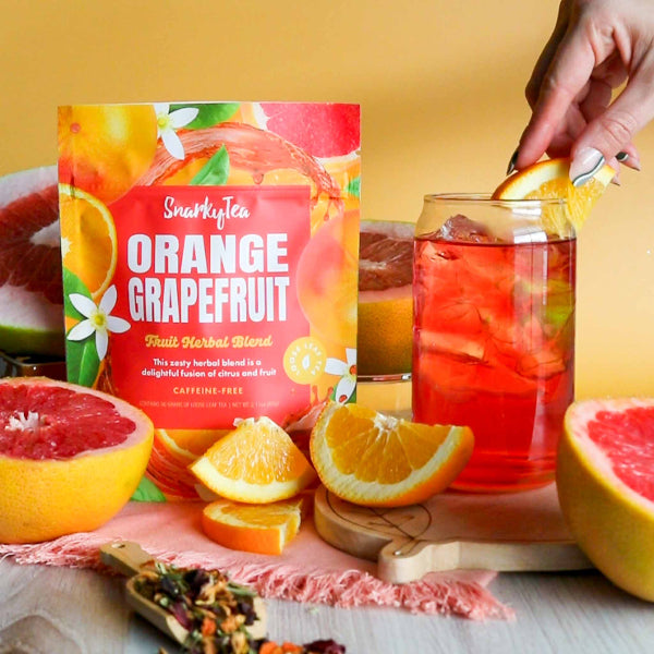 Package of Snarky Tea Orange Grapefruit tea with oranges and blossoms on bag on white background