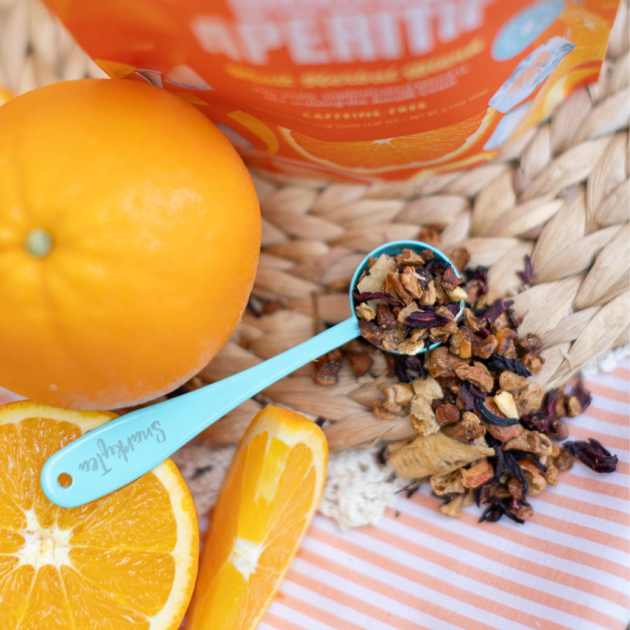 Snarky Tea Orange Aperitif fruit herbal blend packaging with orange slices and ice cubes on a white background.